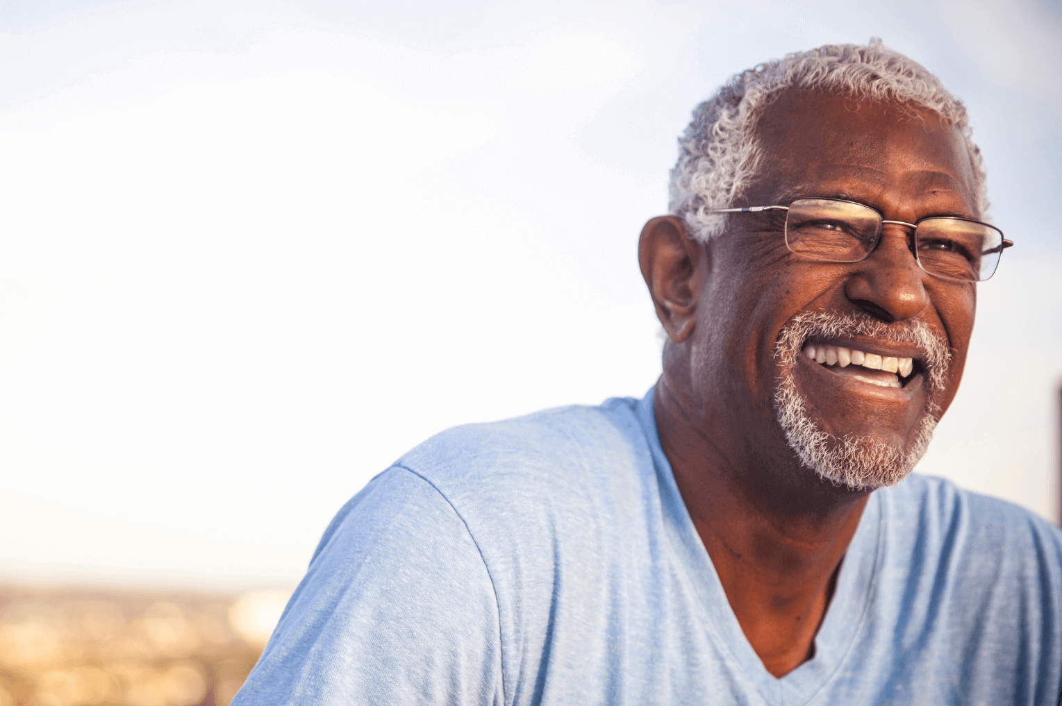 Elderly man smiling showing his dental implants