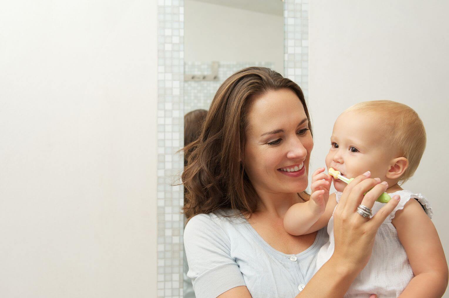 mother brushing her baby's teeth
