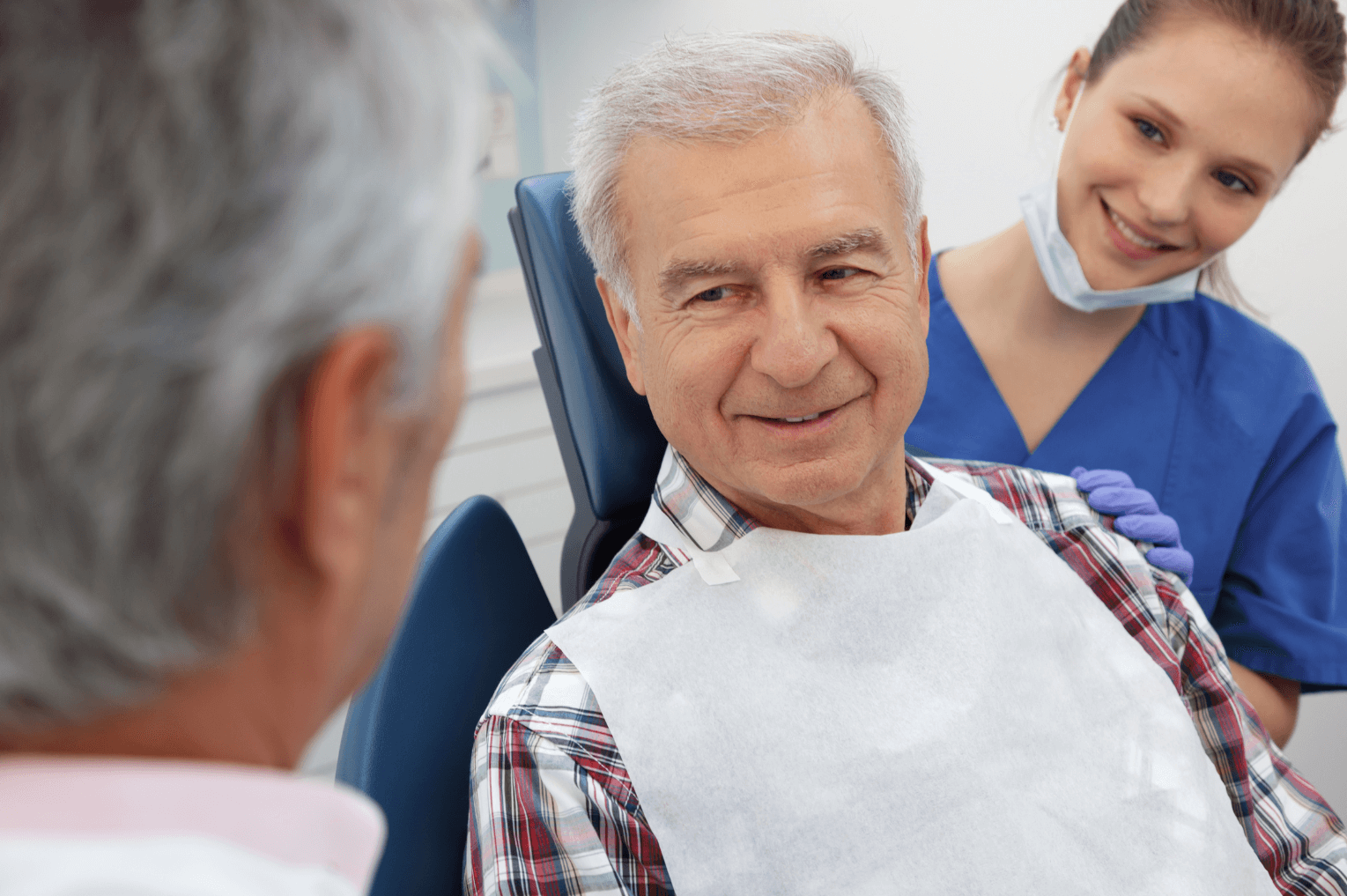 man smiling at dental consultation with nurse behind him