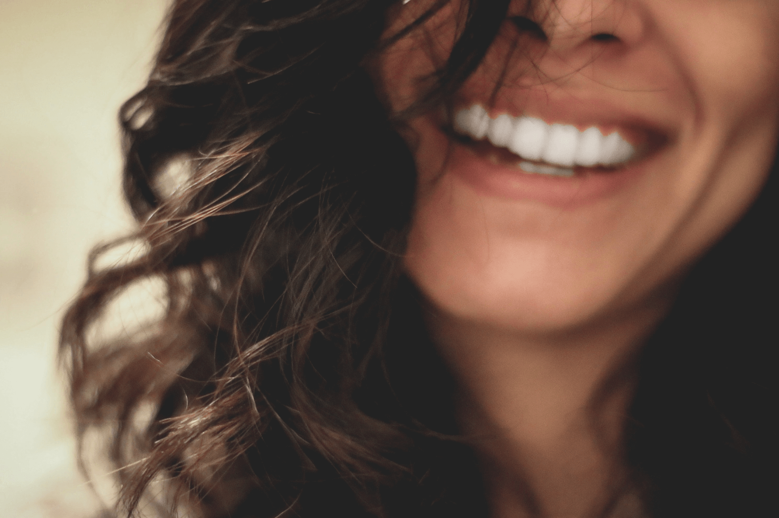 brunette woman smiling after Invisalign at 19 Wimpole Street