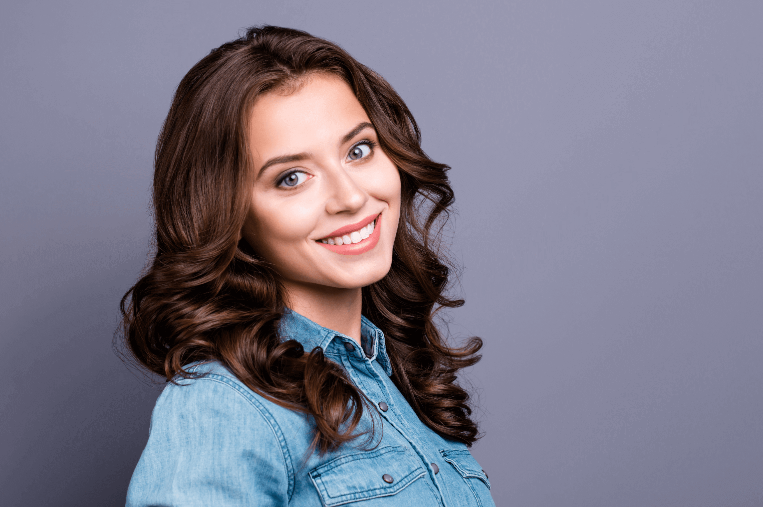 brunette woman smiling to showcase discreet tooth implants in Marylebone