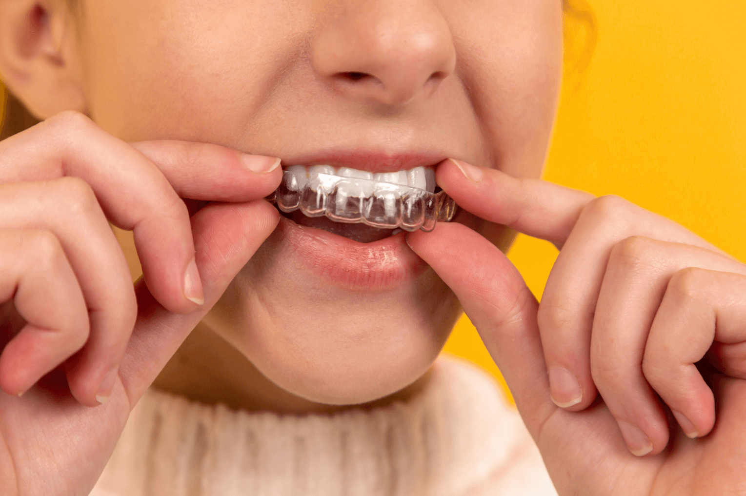 Woman putting on invisalign (London)