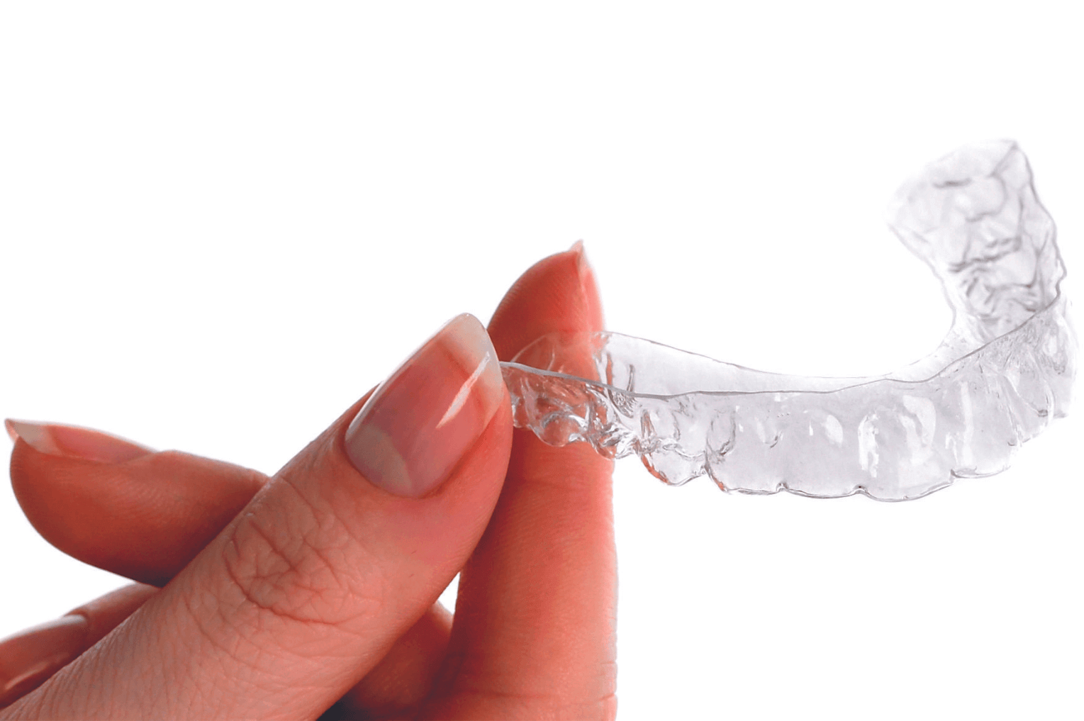 Womans hand holding Invisalign aligners from us at 19 Wimpole Street Dental Practice, Marylebone, London.