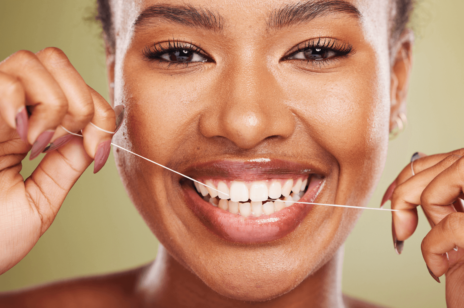 Woman shown flossing her teeth after receiving dental hygiene advice from 19 wimpole street dental in london